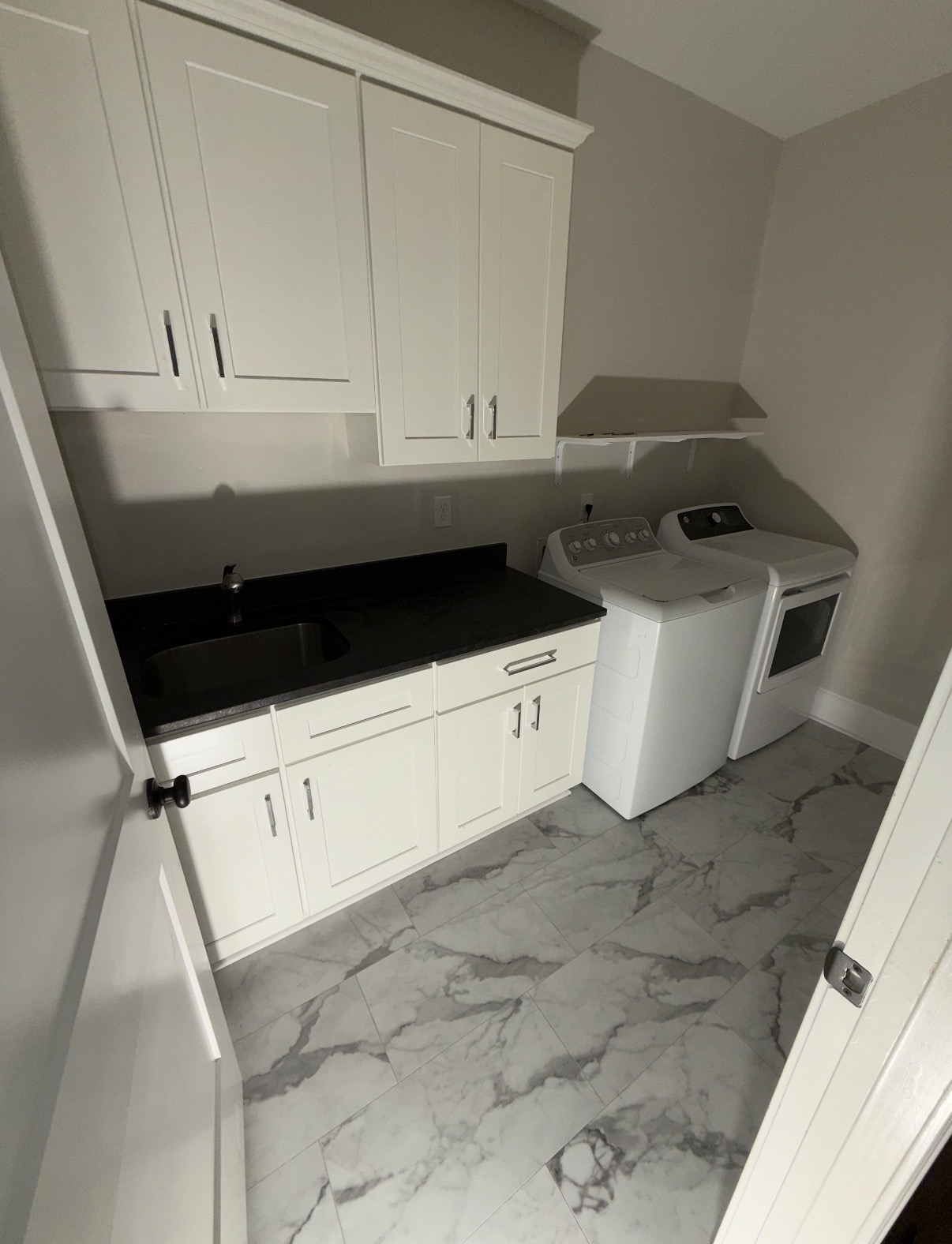 Finished laundry room with white cabinetry and marble-look tile flooring — Laundry Room Drywall Repair & Tile Floor in Lexington, SC